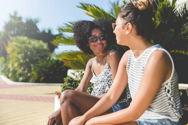 Zwei junge Freundinnen sitzen draußen und reden — Stockfoto