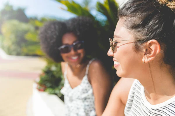 Junge glückliche Frau sitzt draußen mit Freund lächelnd — Stockfoto