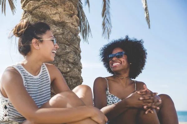 Plaj gülüyor üzerinde oturan iki genç kadın