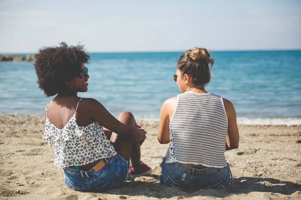Zwei Frauen entspannen sich am Strand und unterhalten sich — Stockfoto