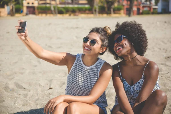 Zwei Freundinnen fotografieren sich am Strand — Stockfoto