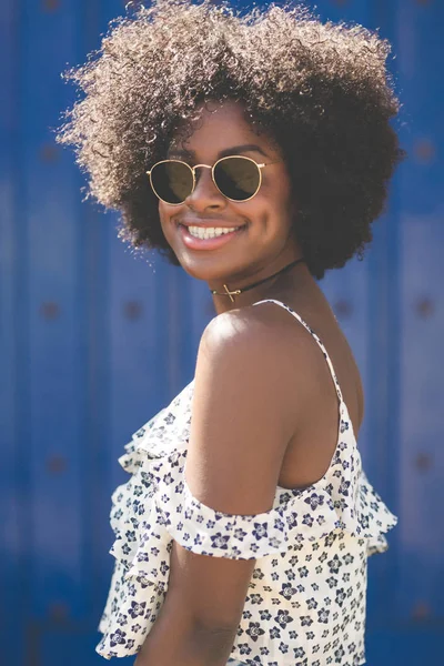 Jeune afro américaine femme sur fond bleu souriant — Photo