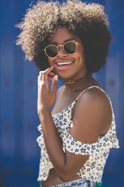 青色の背景の笑いに若い美しいアフロ ・ アメリカ人女性 — ストック写真