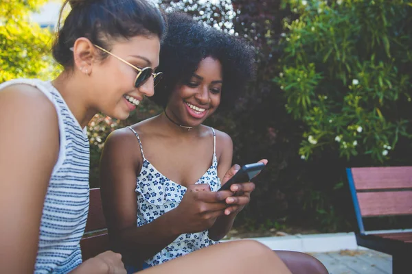 Tezgah telefon kullanarak oturan mutlu genç arkadaşlar