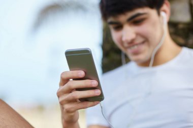 Mutlu genç adam akıllı telefon üzerinden müzik dinleme