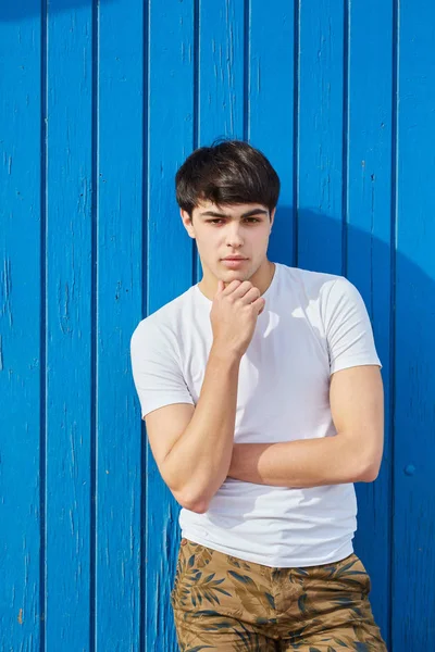 Genç adam yakışıklı adam karşı mavi arka plan ayakta