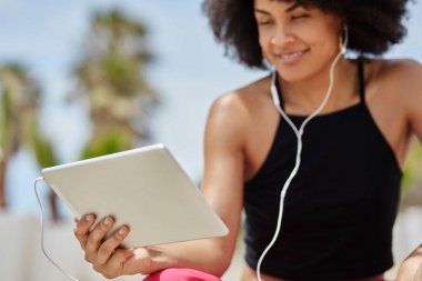 Mutlu afro Amerikalı kadın tablet müzik dinleme
