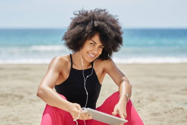 Mutlu afro Amerikalı kadın plaj t müzik dinleme üzerinde rahatlatıcı