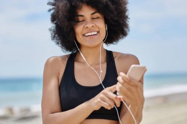 Mobil gülümseyen üzerinde Afro Amerikalı kadın dinleme audiobook