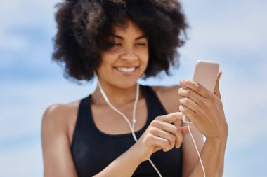 Mutlu afro Amerikalı kadın mobil müzik dinleme