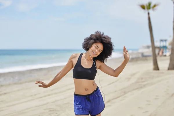 Afro femme américaine écouter de la musique danser sur la plage heureux — Photo