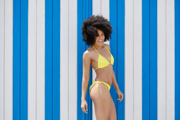 Dość afro amerykańska dziewczyna w bikini żółty, śmiejąc się, patrząc od hotelu — Zdjęcie stockowe