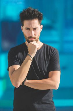Genç ciddi propping çenesine yandan adam