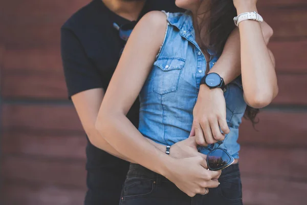 Pareja abrazándose juntos sosteniendo gafas de sol — Foto de Stock