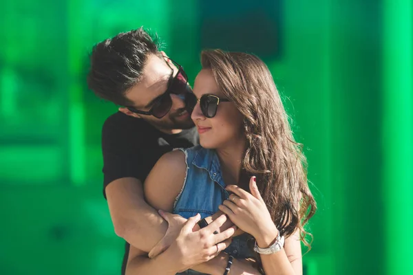 Jovem casal de óculos de sol abraçando juntos — Fotografia de Stock