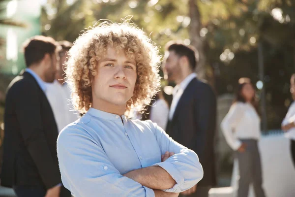 Young businessman standing with crossed arms outside — Stock Photo, Image