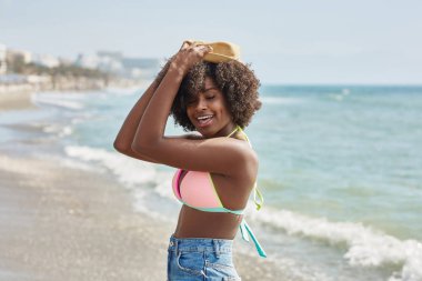 Baş gülümseyen üzerinde şapka tutan oldukça afro Amerikan kız