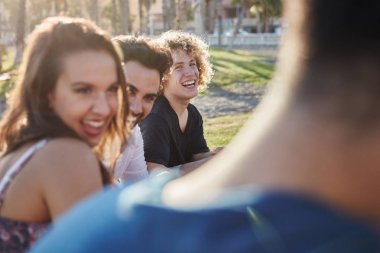 Arkadaşlarla gülmek dışında oturan genç insanlar