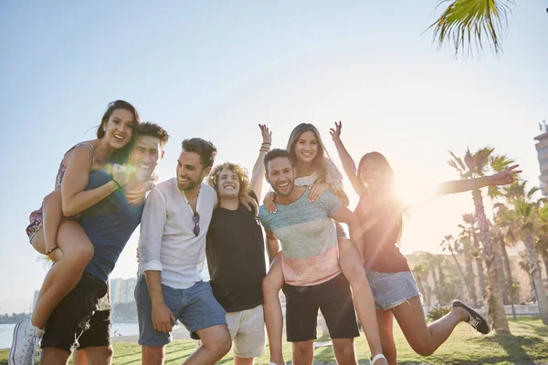 Jovens amigos se divertindo juntos na luz do sol ao ar livre — Fotografia de Stock