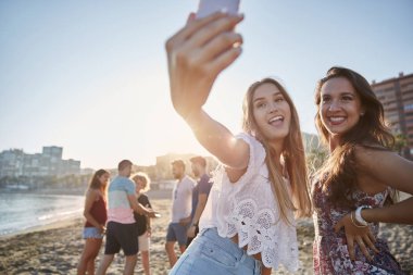 İki mutlu erkek arkadaş selfie kumsalda alarak