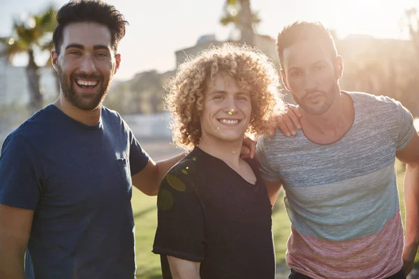 Üç erkek arkadaş birlikte ayakta dışında güneş ışığı altında