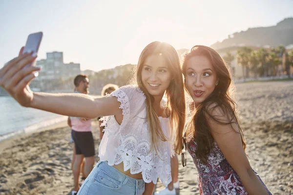Dva docela kamarády při selfie na pláži — Stock fotografie