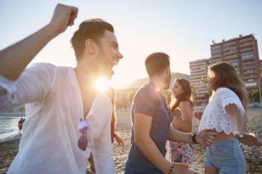 Genç erkek arkadaşlarıyla sahilde dans