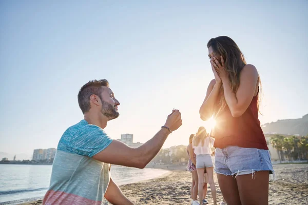 Νεαρός άνδρας που προτείνει την φίλη του στην παραλία — Φωτογραφία Αρχείου