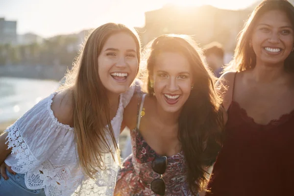 Drei glückliche Freundinnen stehen zusammen am Strand — Stockfoto