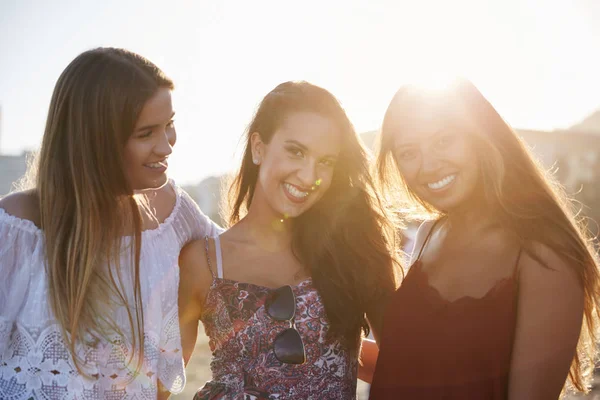 Drie mooie vriendinnen staan samen op het strand glimlachen — Stockfoto