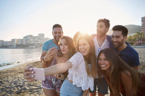 Glückliches Mädchen macht Selfie mit Freunden am Strand — Stockfoto