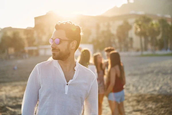 Ritratto di bell'uomo con gli occhiali da sole che distoglie lo sguardo sorridente — Foto Stock