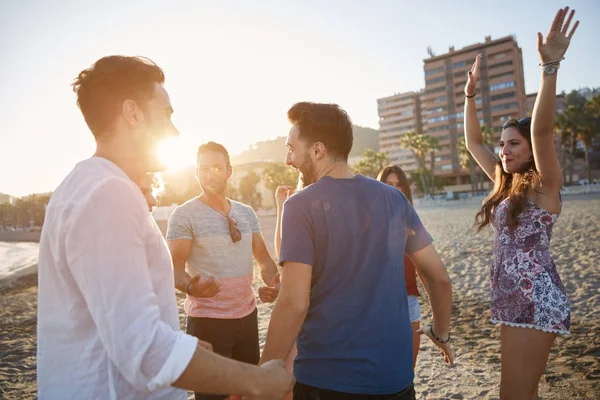 Grupo de pessoas felizes dançando na praia — Fotografia de Stock