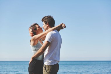 Mutlu çift birbirlerine deniz kenarında kucaklayan