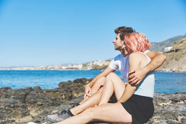 Casal feliz abraçando na rocha à beira-mar — Fotografia de Stock