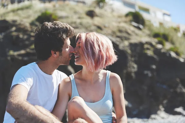 Feliz pareja sentado juntos fuera besos — Foto de Stock