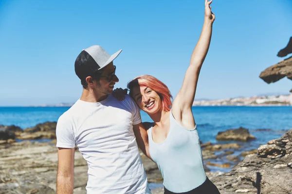 Glückliche Frau lehnt sich gegen ihren Freund, der die Hand hebt — Stockfoto