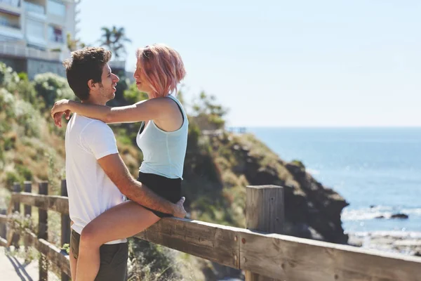 Mujer feliz sentada en la cerca mirando a su novio —  Fotos de Stock