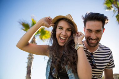 Şapka ve onun erkek arkadaşı gülerek giyen genç kadın