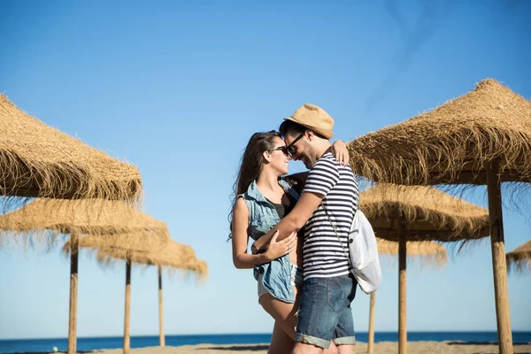 Gelukkige paar knuffelen op strand kijken naar elkaar — Stockfoto