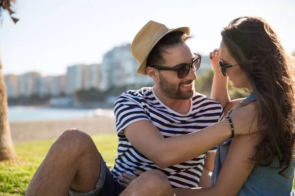 Šťastný mladý muž sedí venku s přítelkyní se jí dotýkat — Stock fotografie