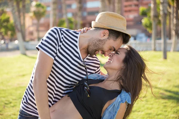 Feliz hombre sosteniendo a su novia en brazos riendo — Foto de Stock