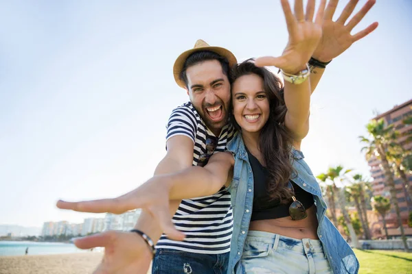 Glückliches Paar hebt lachend die Hände vor sich — Stockfoto