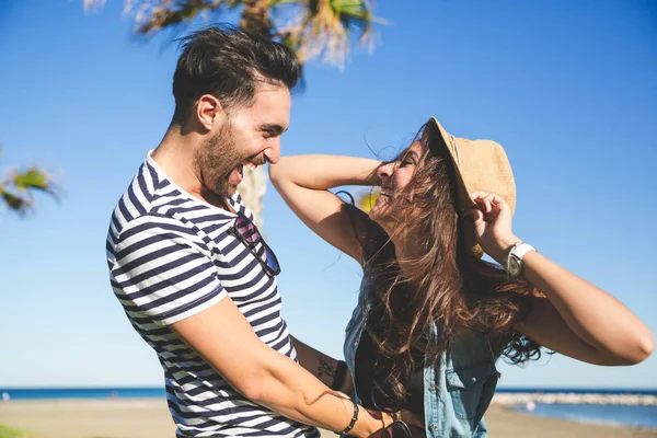 Mujer feliz usando sombrero riendo con su novio —  Fotos de Stock