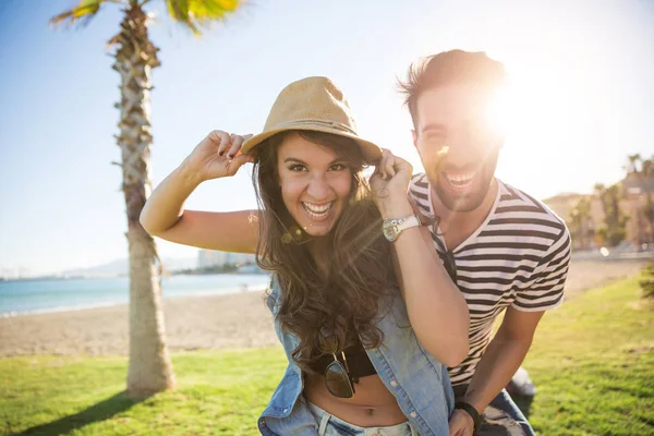 Jovem casal feliz rindo lá fora à luz do sol — Fotografia de Stock