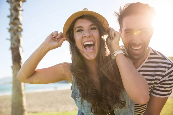 Couple heureux sur la plage riant au soleil — Photo