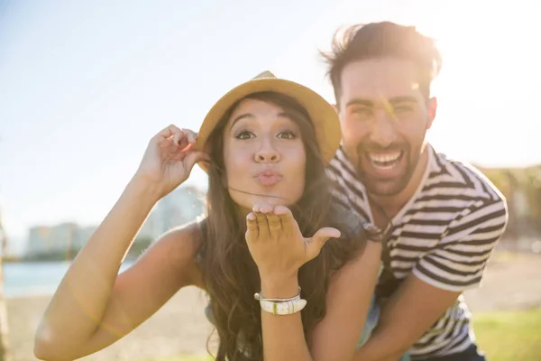 Bella donna in cappello invio bacio con fidanzato dietro di lei — Foto Stock