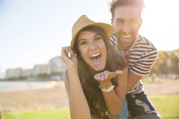 Glückliche Frau mit Hut lacht mit ihrem Freund draußen — Stockfoto