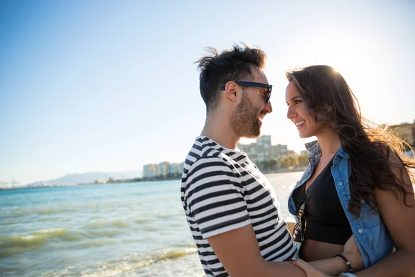 Pareja feliz parada a la orilla del mar mirándose el uno al otro —  Fotos de Stock