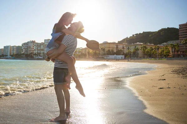 Happy man carrying his girlfriend on hands kissing her